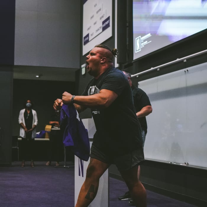 Defensive lineman Joe Spivak receives the No. 1 jersey from head coach Pat Fitzgerald.